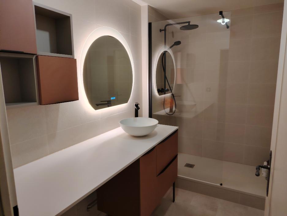 Salle de bain rénovée avec double vasque et miroir LED