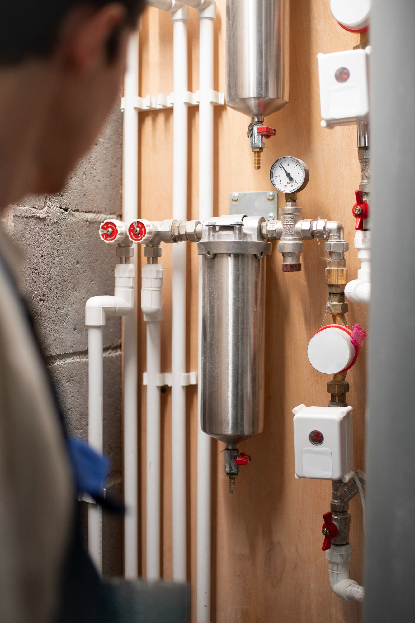 Plombier raccordant les tuyaux d'alimentation d'un nouveau chauffe-eau électrique.